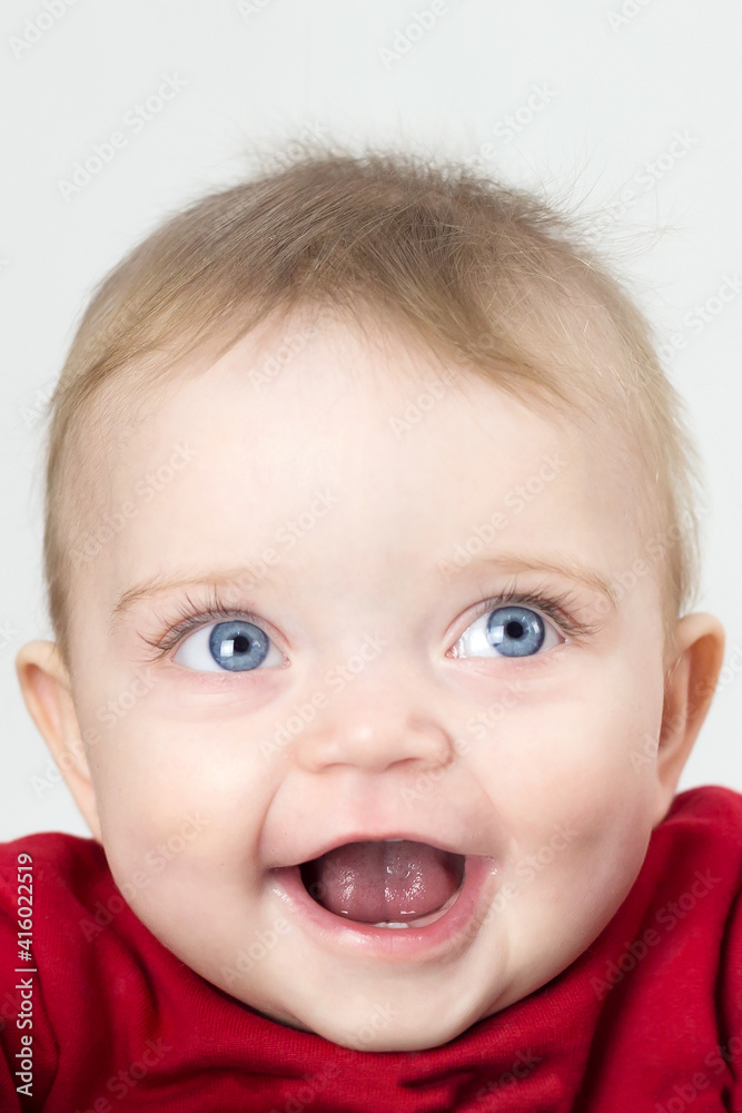 A child with wide open eyes looks directly on a white background A child with wide open eyes looks directly on a white background