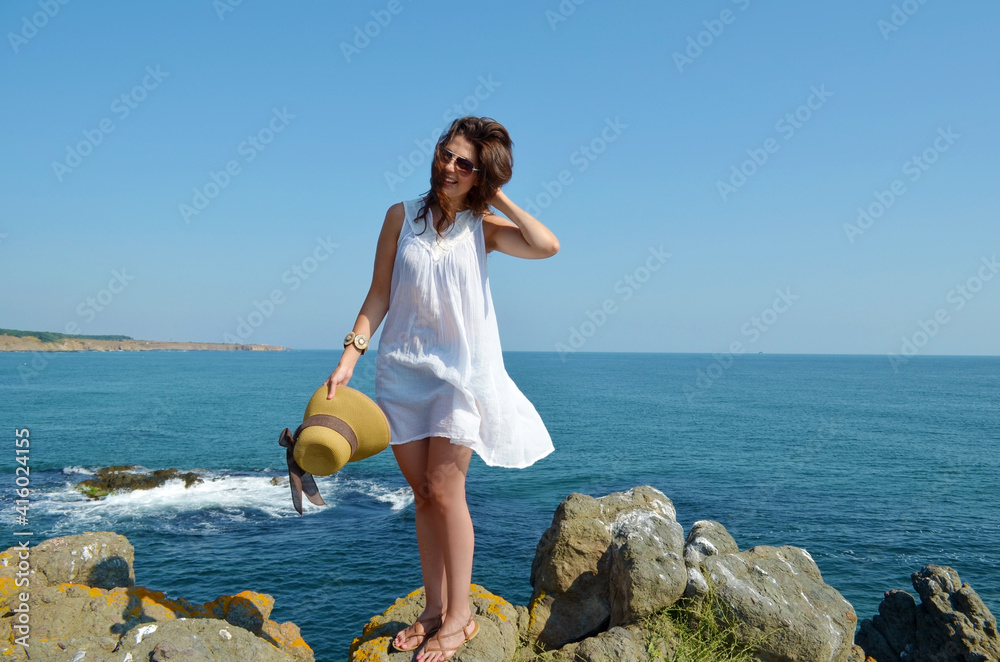 Young Woman Standing on a Rocks Above the Sea Young Woman Standing on a Rocks Above the Sea