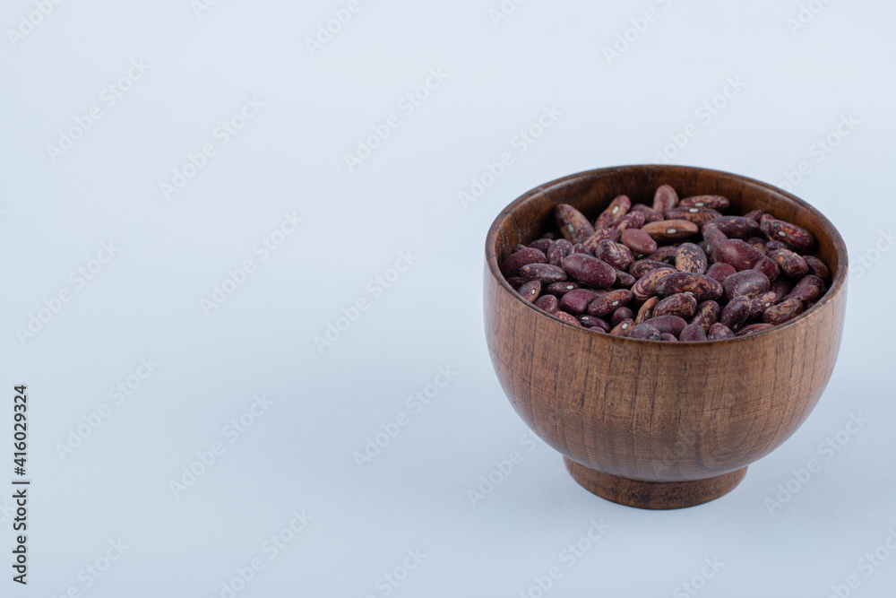 Heap of uncooked dried red beans in wooden bowl Heap of uncooked dried red beans in wooden bowl