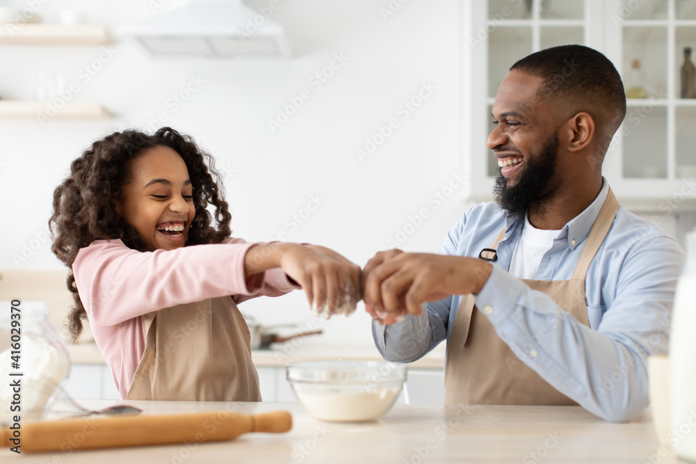 Happy black man and his daughter preparing dough Happy black man and his daughter preparing dough