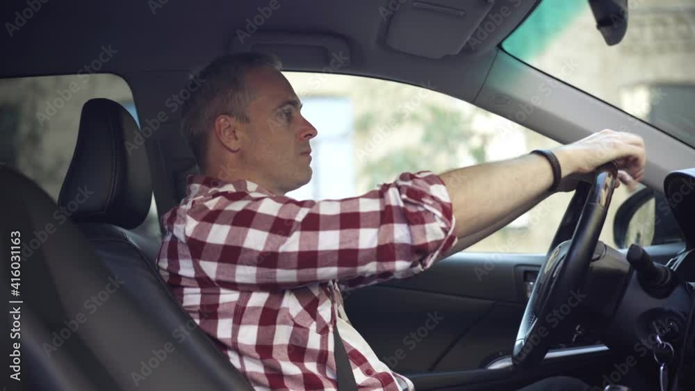 Side view portrait of angry Caucasian man sitting on driver's seat in car thinking. Furious stressed guy in automobile. Problems and depression concept. Side view portrait of angry Caucasian man sitting on driver's seat in car thinking. Furious stressed guy in automobile. Problems and depression concept.