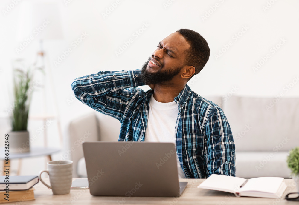Black Man Suffering From Neck Pain After Work In Office Black Man Suffering From Neck Pain After Work In Office
