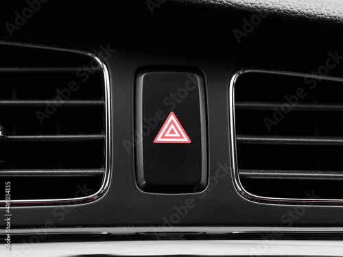 Close-up red emergency hazard light switch button in interior of modern car