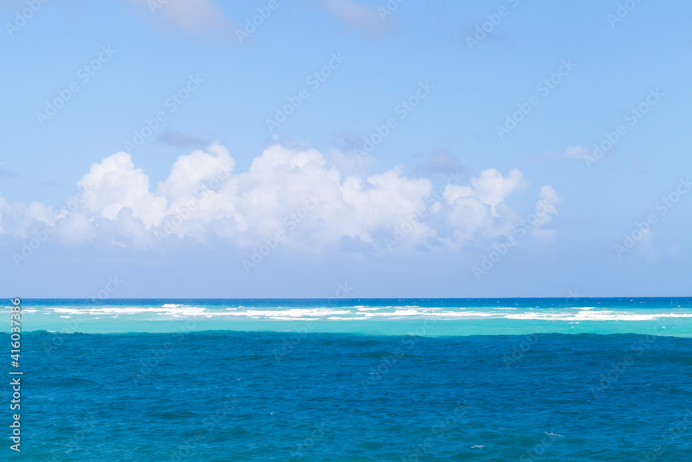 Caribbean Sea water under cloudy blue sky on a sunny day