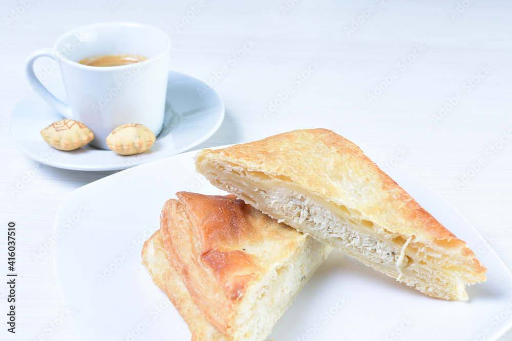 Cup of Colombian coffee, accompanied by baked bakery on white wooden background Cup of Colombian coffee, accompanied by baked bakery on white wooden background