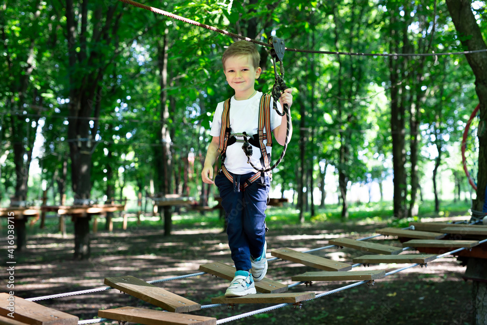 Little active boy who climbs on a rope the way to the amusement Park Little active boy who climbs on a rope the way to the amusement Park