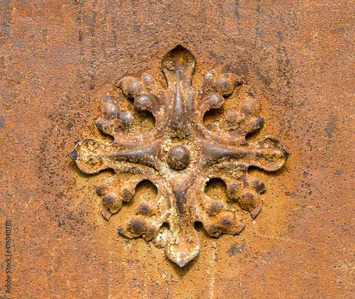 Decorative element made of metal. Metal flower on the wall of the building.