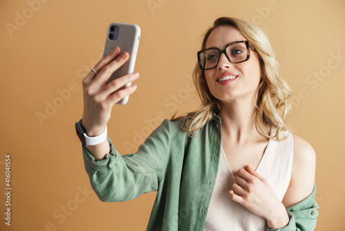 Happy woman smiling while taking selfie on mobile phone