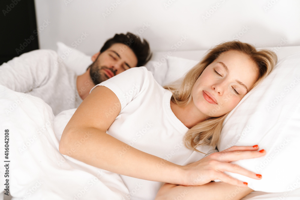 Beautiful young couple sleeping in bed