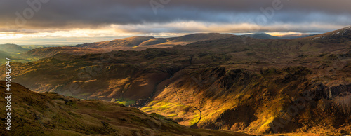 Beautiful light with panoramic view of Western Lake District fells and dramatic dark clouds in the sky. photo