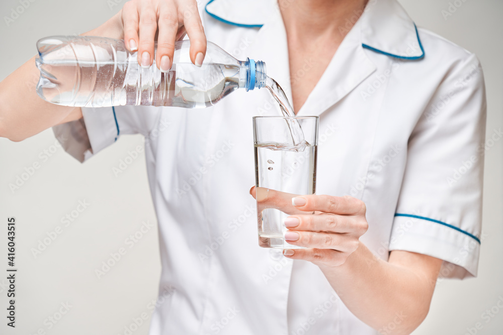 Healthy eating or lifestyle concept - female woman doctor holding and a glass of clear fresh water Healthy eating or lifestyle concept - female woman doctor holding and a glass of clear fresh water