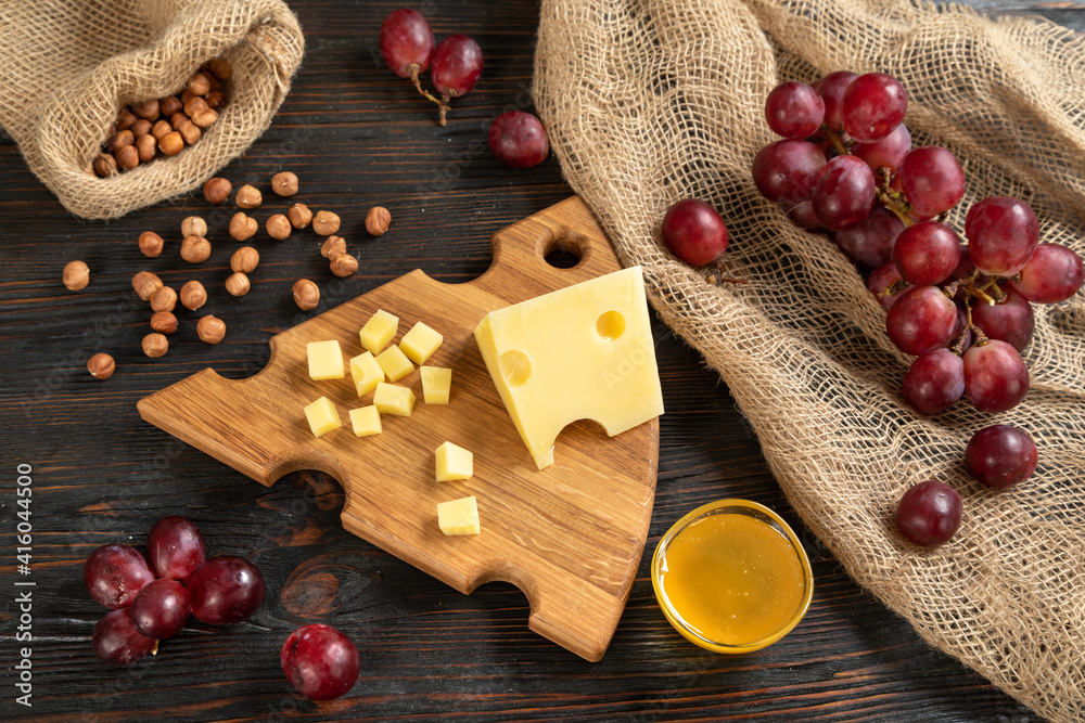 Cheese, grapes and nuts on a cutting board