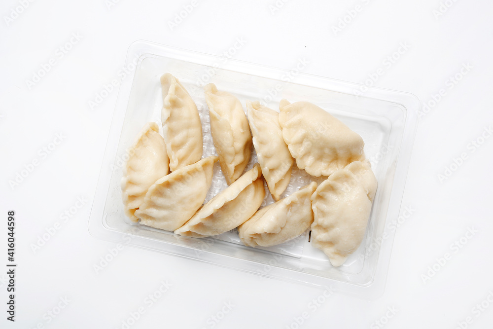 Top view of pierogi, dumplings on a plastic, transparent food tray, isolated on white.