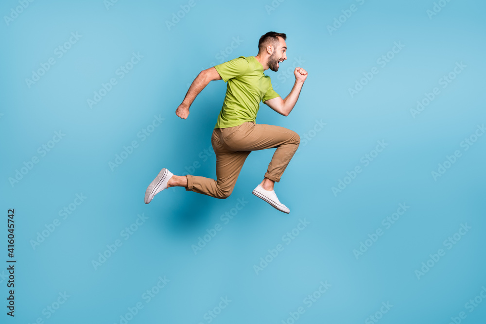 Full size photo of excited man run sale jump up wear brown pants hurry isolated on pastel blue color background Full size photo of excited man run sale jump up wear brown pants hurry isolated on pastel blue color background