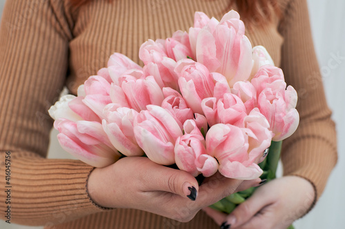 Bouquet of pink tulips in the hands of a woman