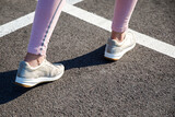 Runner legs running on the road close-up on shoes. Fitness woman jogging workout wellness concept.