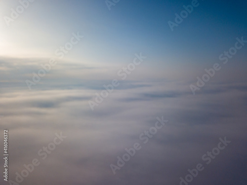 Flight high above the clouds. Aerial drone view.