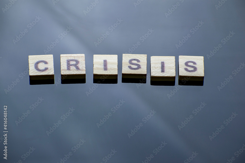 Obraz premium The inscription Crisis on a mirrored dark background with a shopping cart.