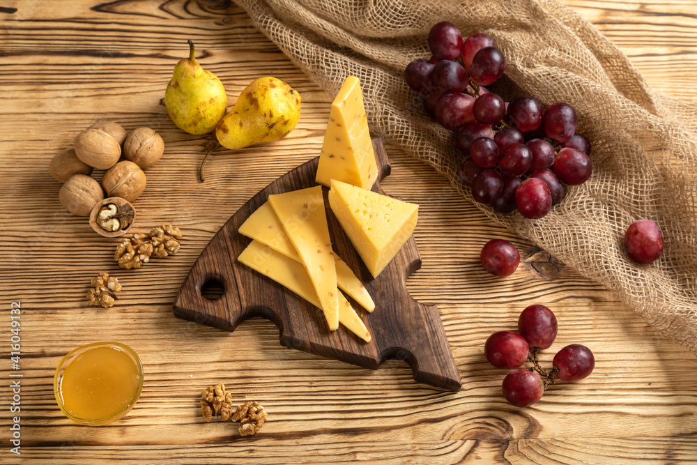 Cheese, grapes and nuts on a cutting board