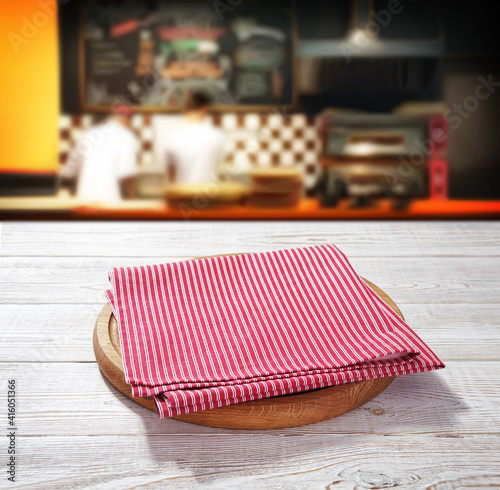 Napkin and board for pizza on wooden desk. Pizzeria background.