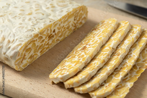 Obraz na płótnie Traditional vegetarian tempeh sliced on a cutting board close up