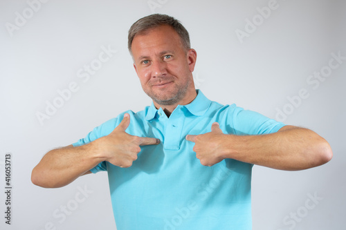 Young man proud of himself over white background.