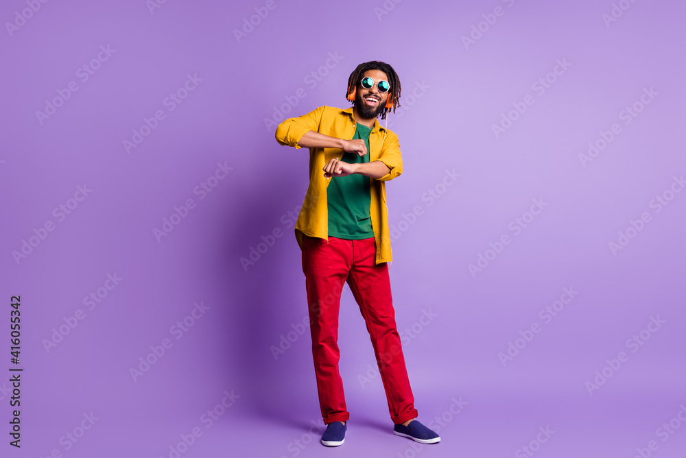 Full size photo of positive handsome dark skin man dance hands toothy smile isolated on violet color background Full size photo of positive handsome dark skin man dance hands toothy smile isolated on violet color background
