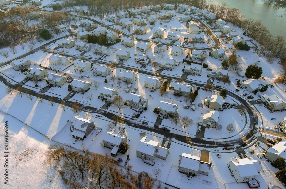 American town on after snowfall USA aerial view of a winter in suburb city with snow covered of residential quarters by the river