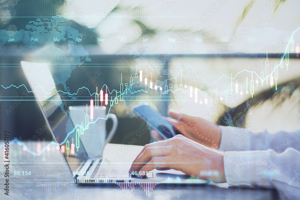 Online stock market concept with man typing on laptop keyboard and digital screen with forex graphs and candlestick Online stock market concept with man typing on laptop keyboard and digital screen with forex graphs and candlestick