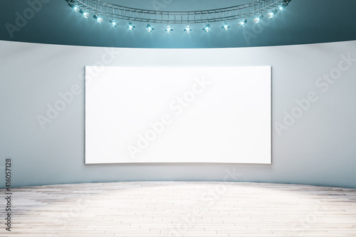 Spacious empty hall room with blank white poster on light wall, parquet floor and led light on top. Mockup © Who is Danny