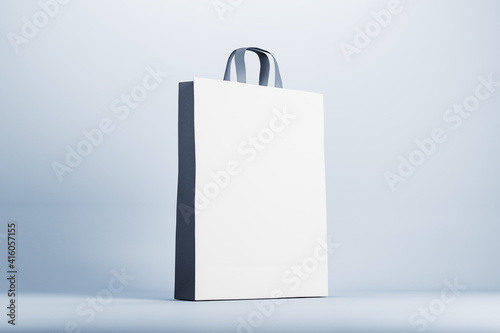 Blank black and white eco paper bag on light surface. Mock up