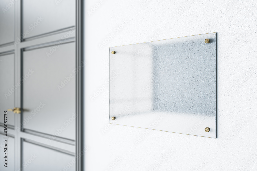 Glass transparent signage on light wall before the entrance a room with