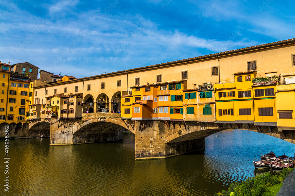 Beautiful close-up view of the medieval bridge Ponte Vecchio over the Arno River in the historic centre of Florence. The bridge with three segmental arches is famous for the shops built along it.