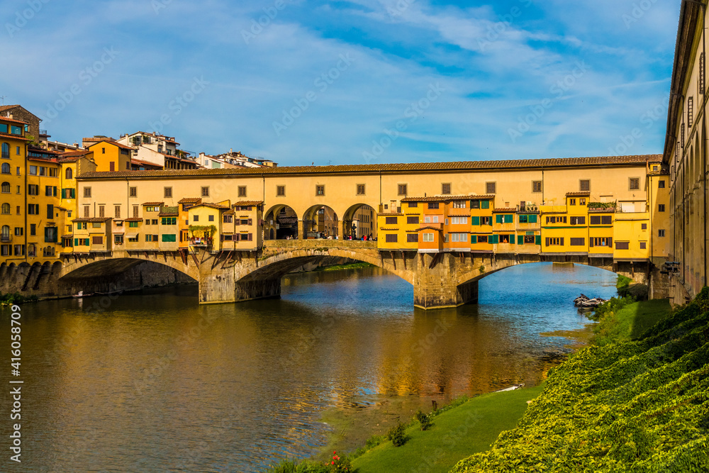 Lovely panoramic view of the bridge Ponte Vecchio, famous for the shops built along it over the Arno River in Florence, Italy. The bridge is a medieval stone closed-spandrel segmental arch bridge.