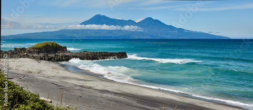 Stunning view of the volcano against the backdrop of the emerald waters of the sea. Iturup island.