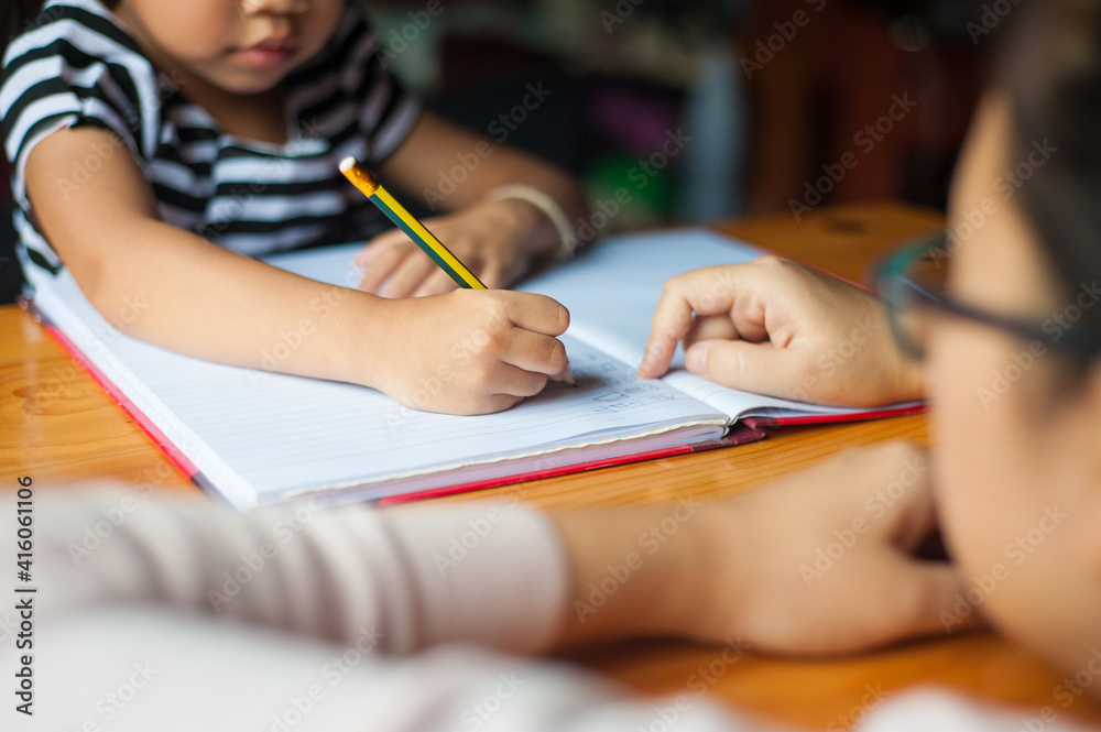 The teacher is teaching little kids homework and practicing writing letters. The teacher is teaching little kids homework and practicing writing letters.