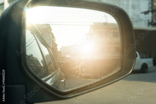 Blurred and side view of car mirror with environment traffic in the city. © thongchainak