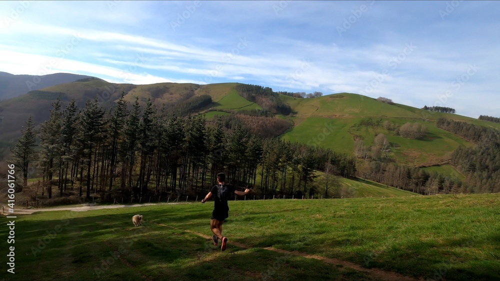 young man trail running in the mointains with his dog young man trail running in the mointains with his dog