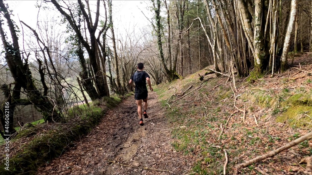 young man trail running in the mountains