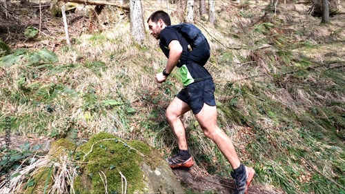 young man trail running in the mointains with his dog