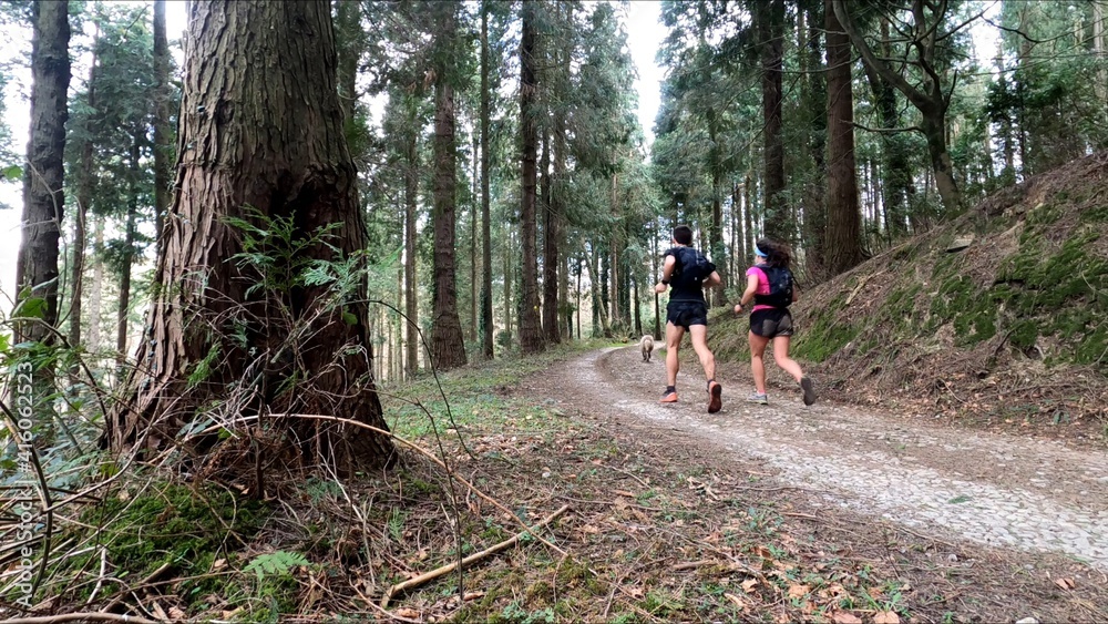 young couple trail running in the mountains young couple trail running in the mountains