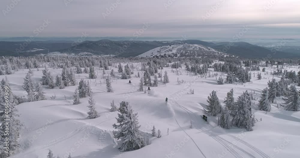 a group of snowmobilers and a snow bike moto. Aerial view of a snowmobile that rides in the middle of a fabulous snowy forest. sport event. Winter fun moto extreme. 4K ProRes 422 HQ a group of snowmobilers and a snow bike moto. Aerial view of a snowmobile that rides in the middle of a fabulous snowy forest. sport event. Winter fun moto extreme. 4K ProRes 422 HQ