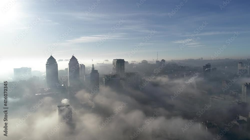 Beautiful drone flight above the fog in the city
