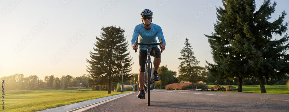 Fototapeta premium Website header of Cropped shot of a man riding mountain bike in park during sunset, cycling outdoors on a summer day