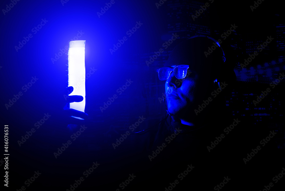 Young man in glasses and headphones on the night party in nightclub with neon lights. Have fun tonight. Holidays entertainment.