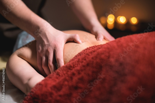 Premium back and lower back massage. Male hands massage the back of a female client