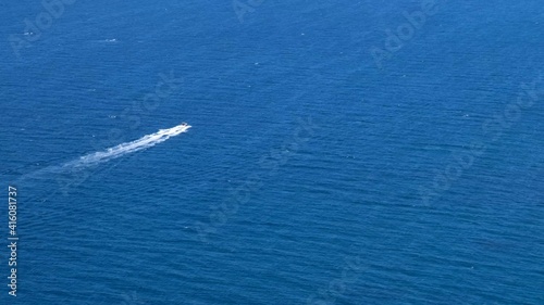 small boat moves on a beautiful blue sea