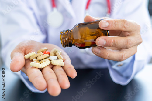 Pharmacist or doctor grasps a bottle of antibiotic capsule into your hand. To explain to the patient how much of the treatment is overdose On the black background table