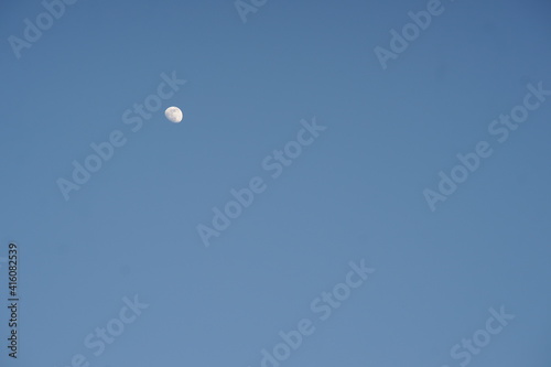 growing moon in clear blue sky during the day