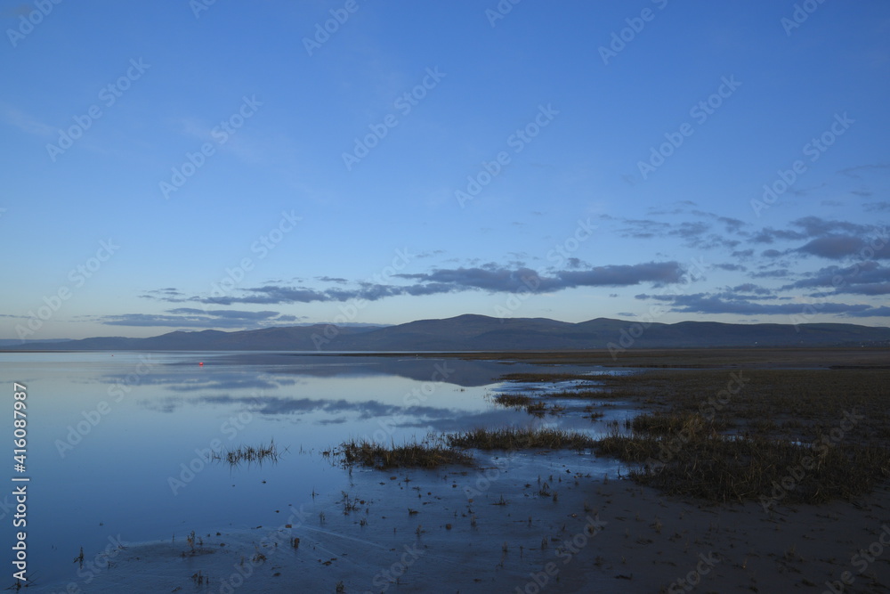 a view of the welsh mountains from ynyslas beach reflected in the estuary